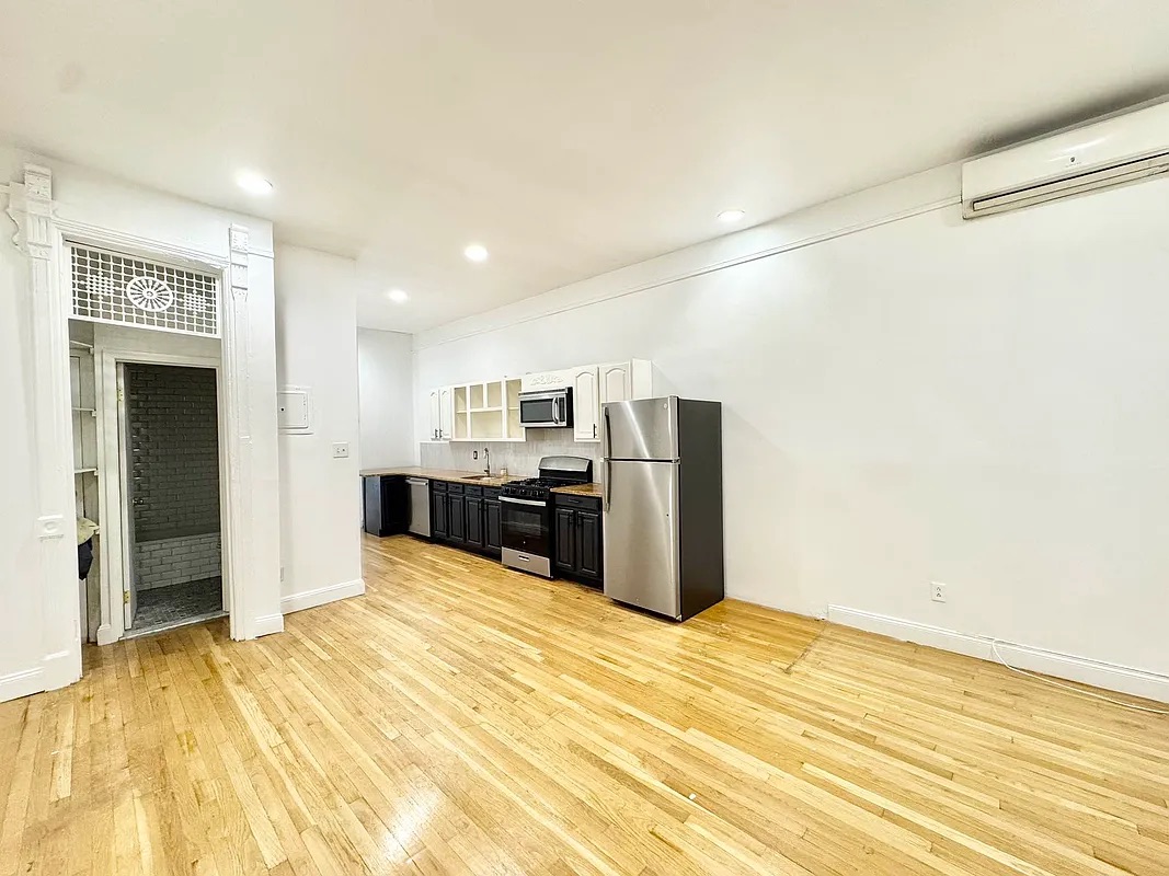 238 Gates Avenue, Unit 2 Brooklyn, NY 11238 - Photo 12 of 13 a view of a kitchen with stainless steel appliances wooden floor and chandelier