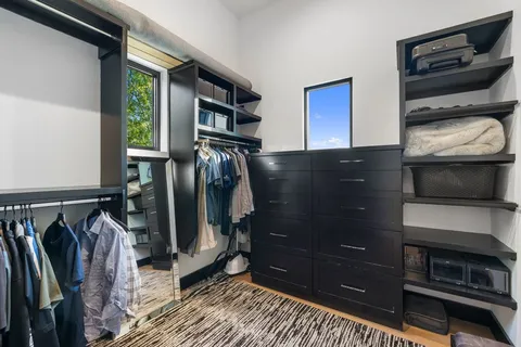 a view of walk in closet with clothes and shoes