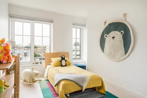 a bedroom with a bed a mirror and windows