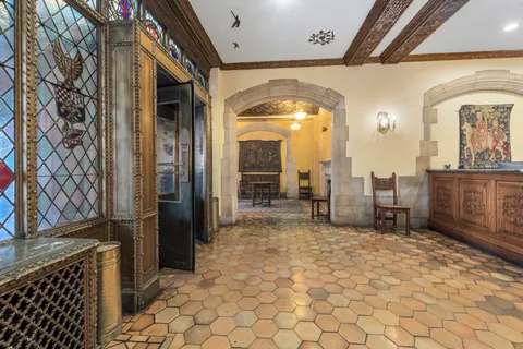 a view of a hallway with a chair and dining table view