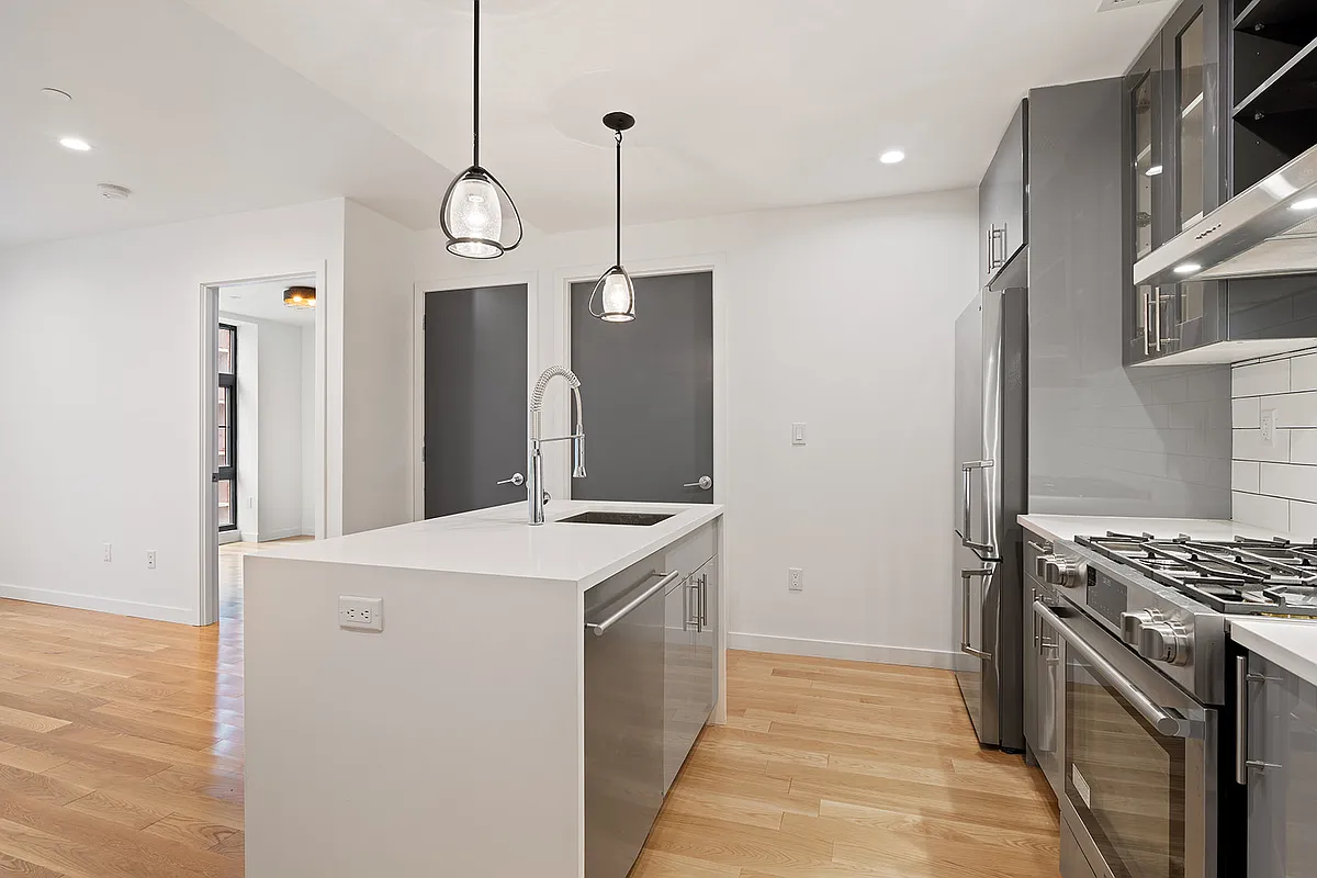 41-21 23rd Street, Unit 6C Queens, NY 11101 - Photo 4 of 10 a kitchen with stainless steel appliances granite countertop a sink a stove and a refrigerator