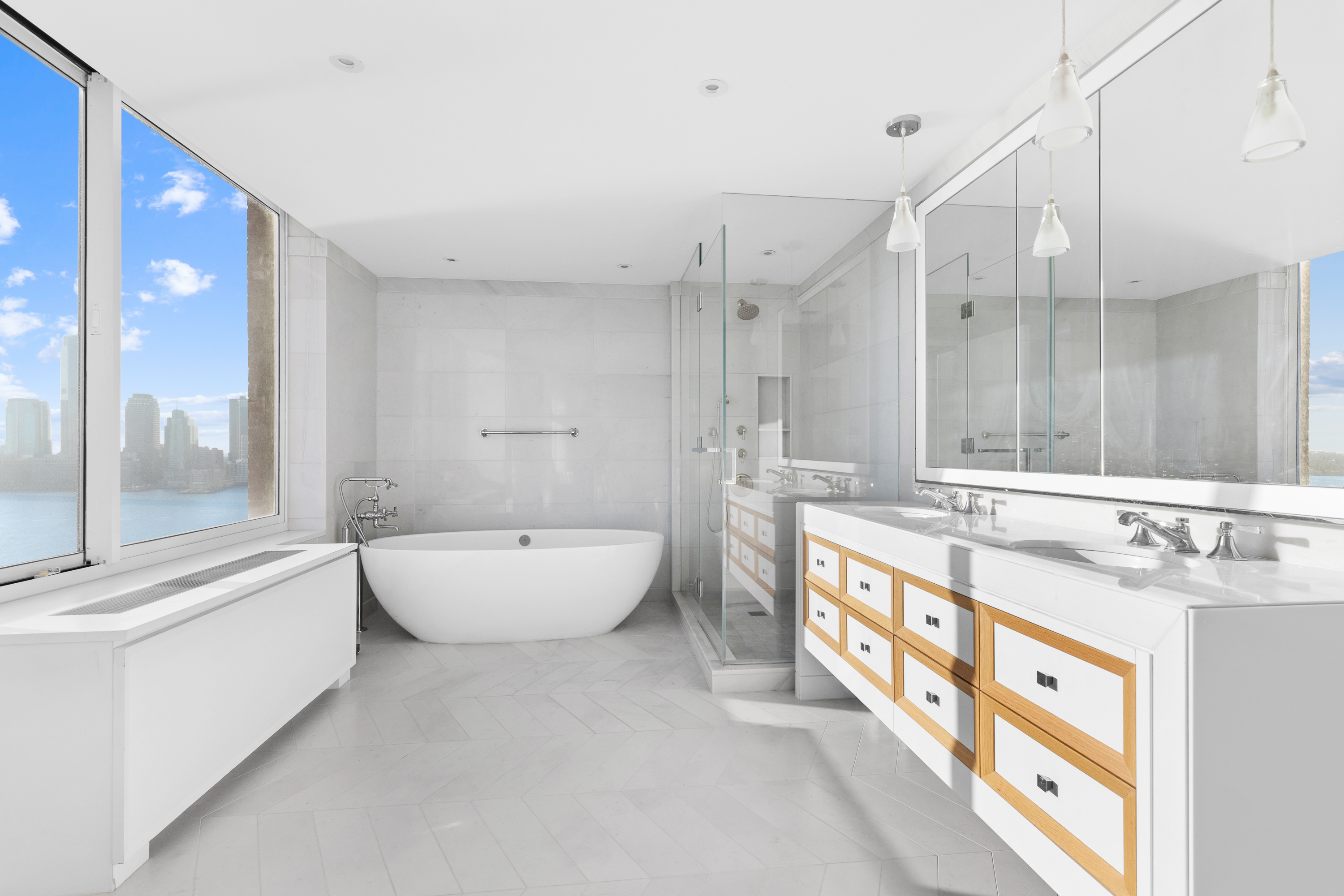 212 Warren Street, Unit 20A Manhattan, NY 10282 - Photo 11 of 23 a spacious bathroom with a double vanity sink a large mirror and a bathtub