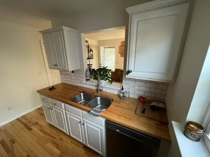 a kitchen with sink a stove and cabinets