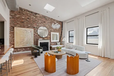 a living room with furniture a fireplace and a potted plant