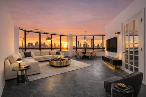 a living room with furniture and floor to ceiling window