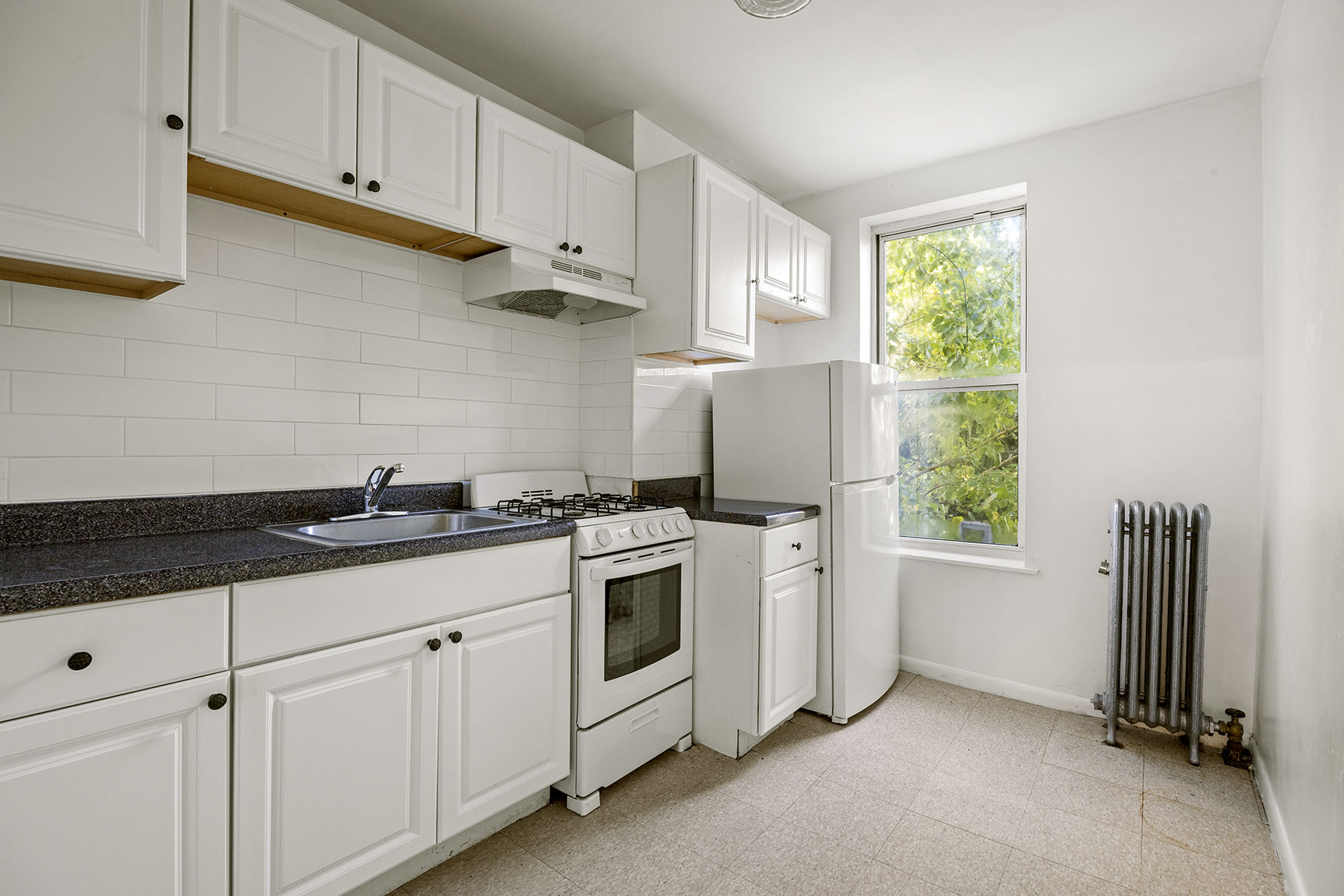 1437 Lincoln Place Brooklyn, NY 11213 - Photo 7 of 12 a kitchen with white cabinets and window