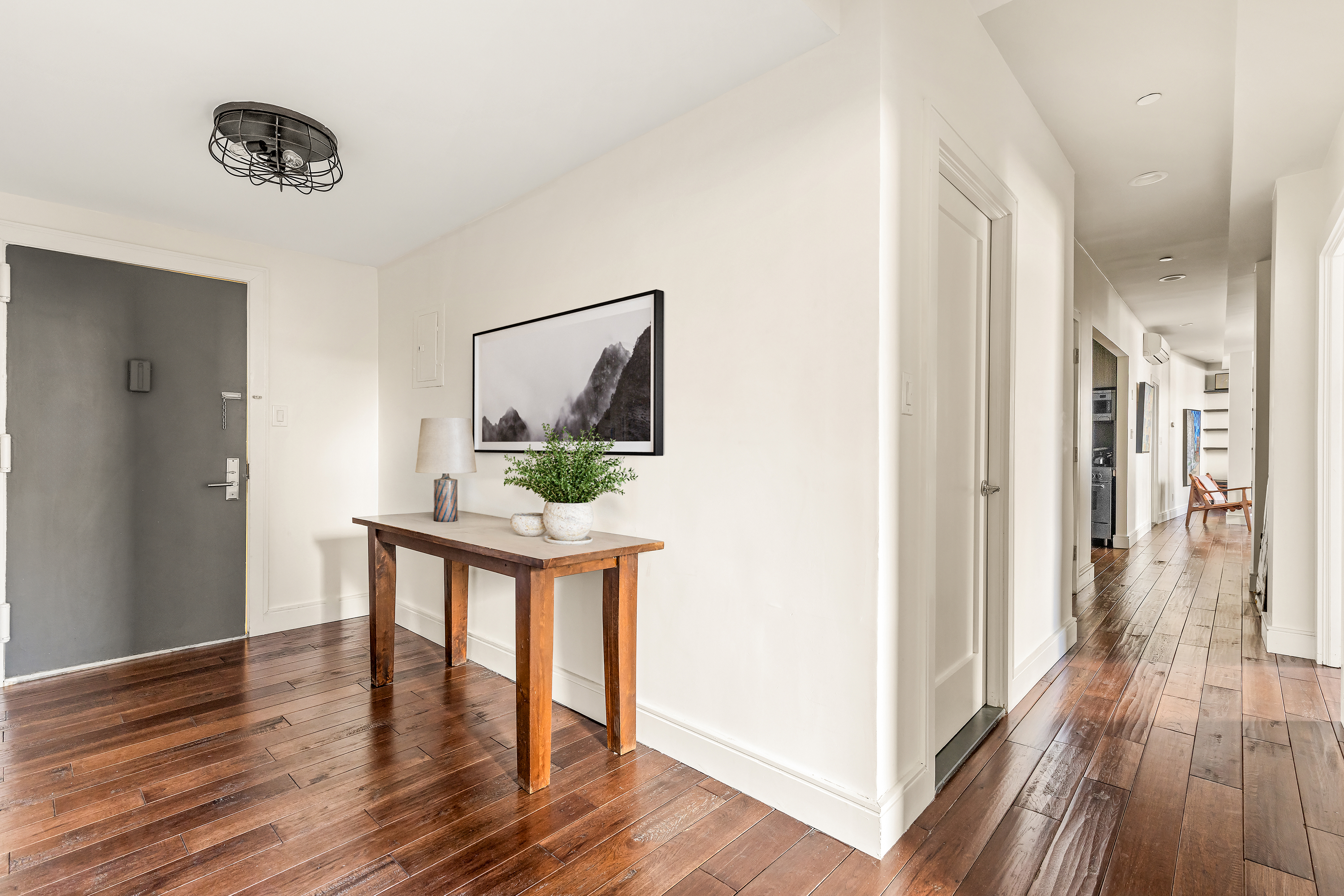 264 Water Street, Unit 6C Manhattan, NY 10038 - Photo 4 of 9 a room with wooden floor and glass door