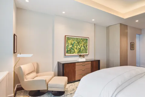 a bedroom with a large bed and a potted plant