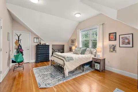 a bedroom with a bed table and a flat screen tv