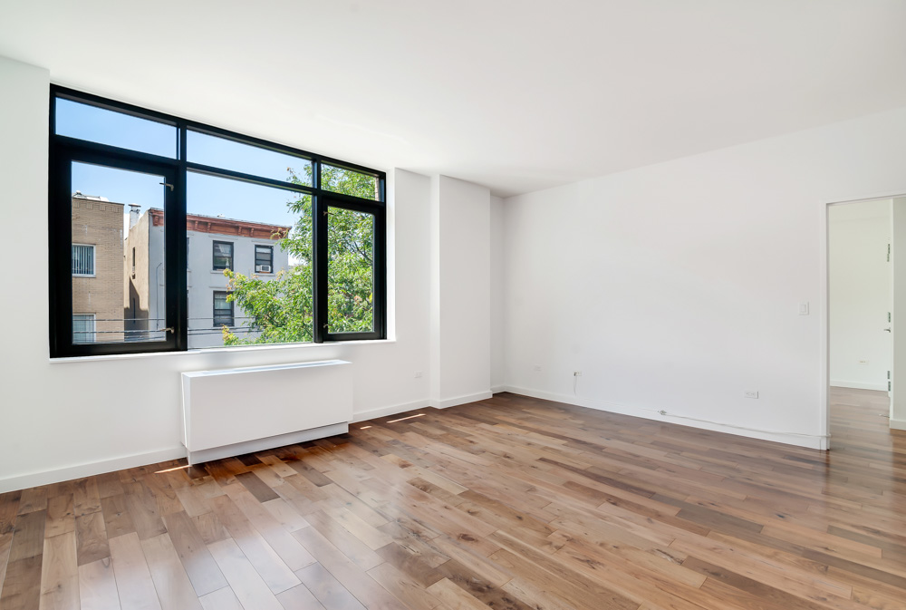 125 North 5th Street, Unit 3D Brooklyn, NY 11249 - Photo 3 of 10 a view of an empty room with wooden floor and a window