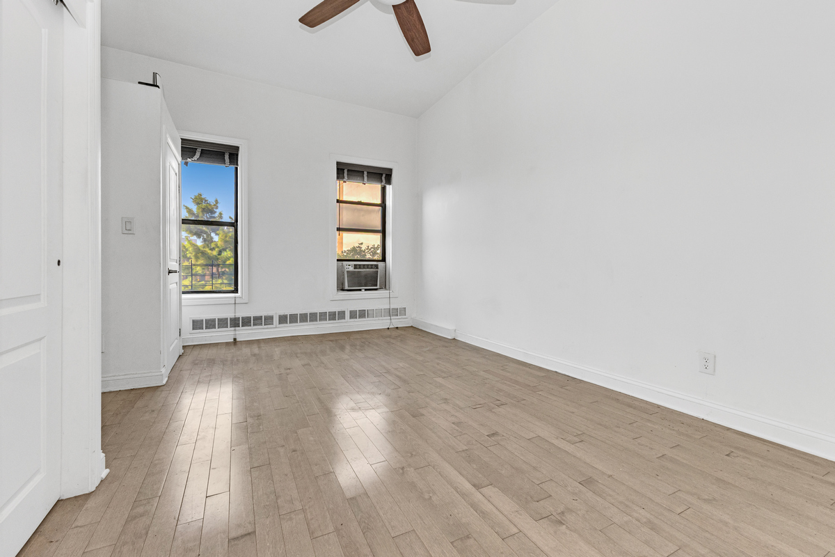 521 Dean Street, Unit 4L Brooklyn, NY 11217 - Photo 10 of 17 an empty room with wooden floor and windows