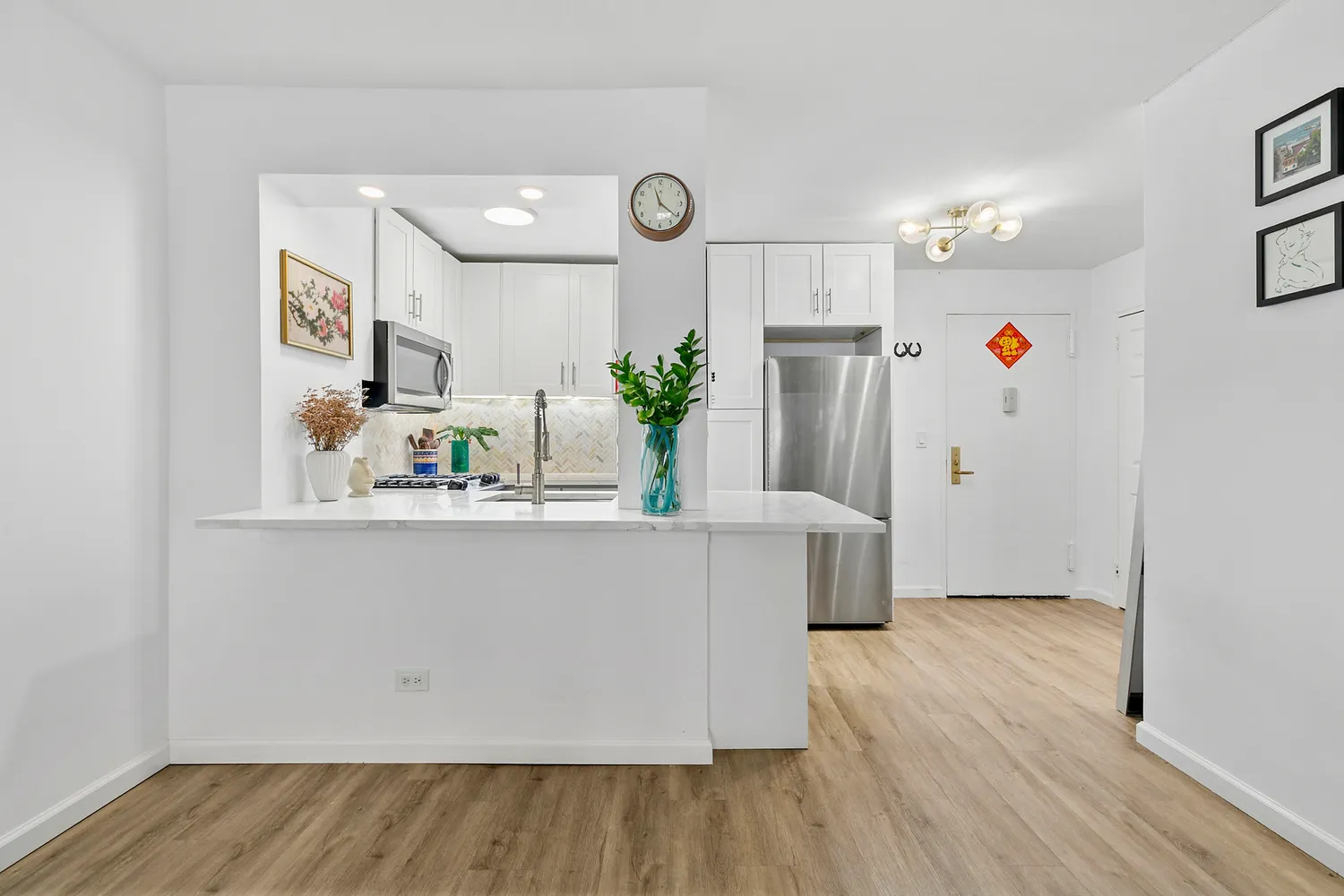 a living room with kitchen island a wooden floor and refrigerator
