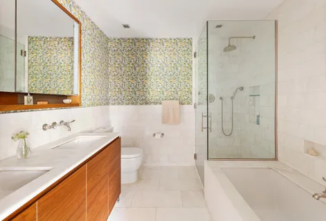 a bathroom with a granite countertop sink a toilet and shower