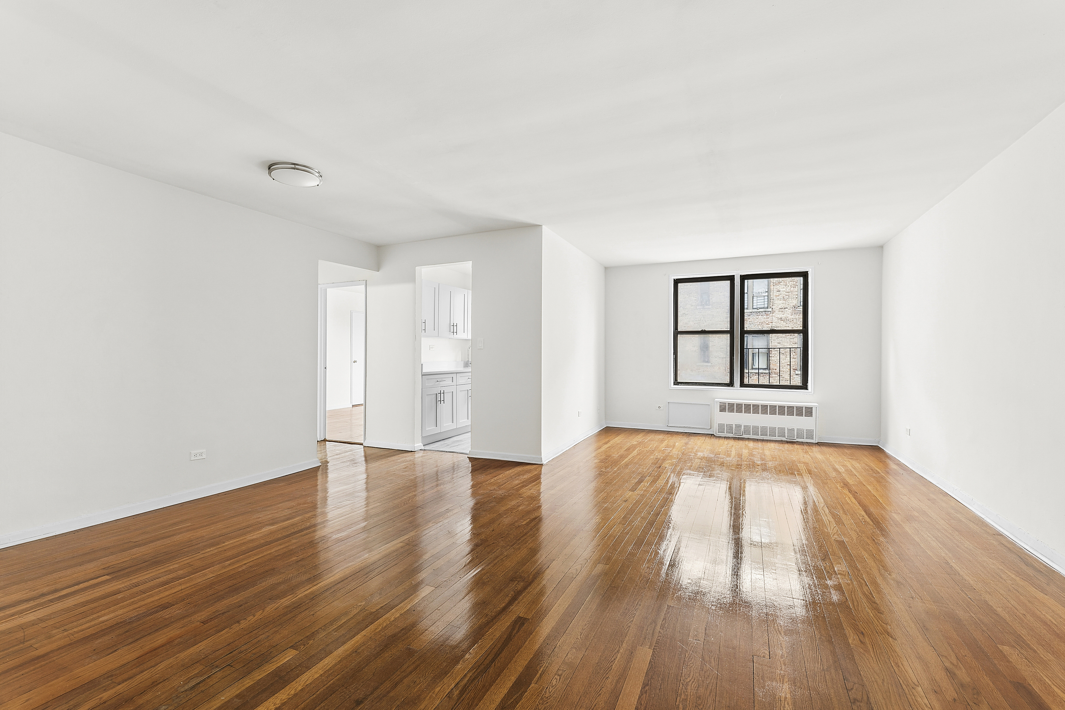6645 Broadway, Unit 7E Bronx, NY 10471 - Photo 5 of 11 a view of an empty room with wooden floor and a window