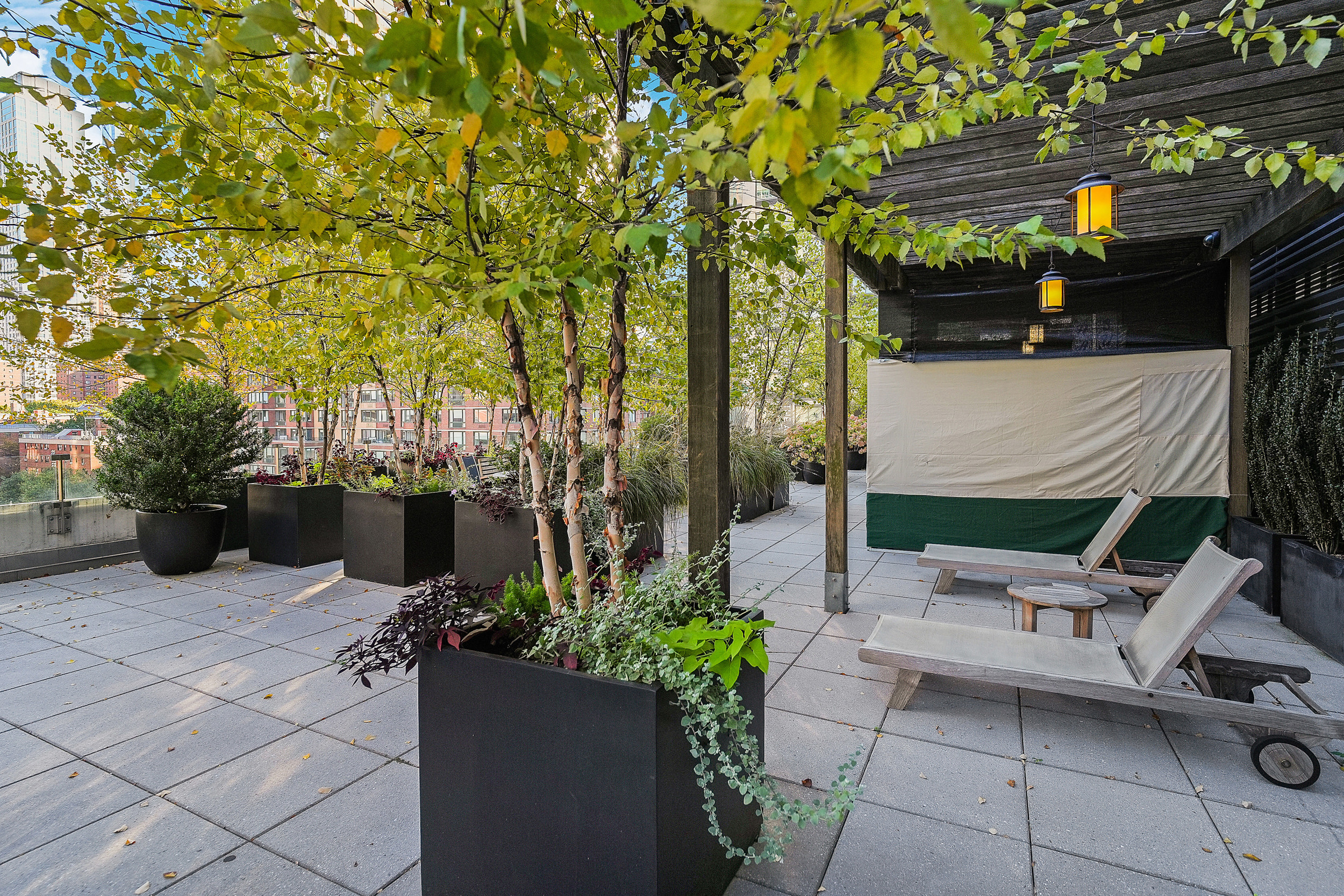 80 Riverside Boulevard, Unit 4H Manhattan, NY 10069 - Photo 8 of 17 a view of a patio with table and chairs potted plants and large tree