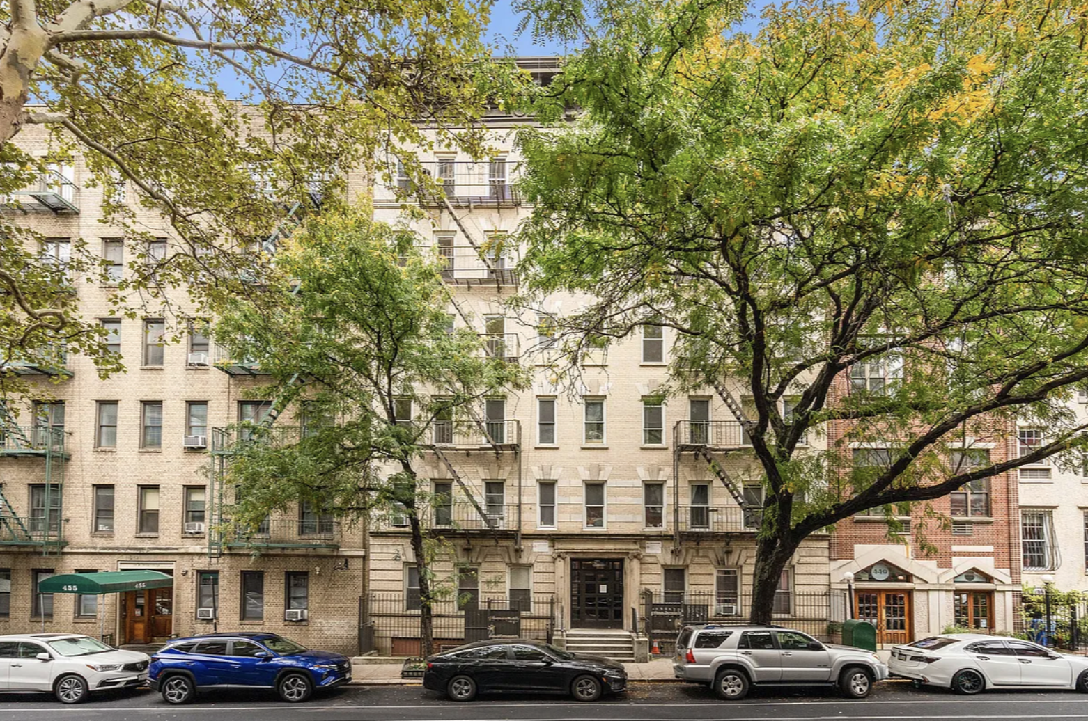 451 West 44th Street, Unit 36 Manhattan, NY 10036 - Photo 5 of 18 a front view of a building with lot of cars and trees