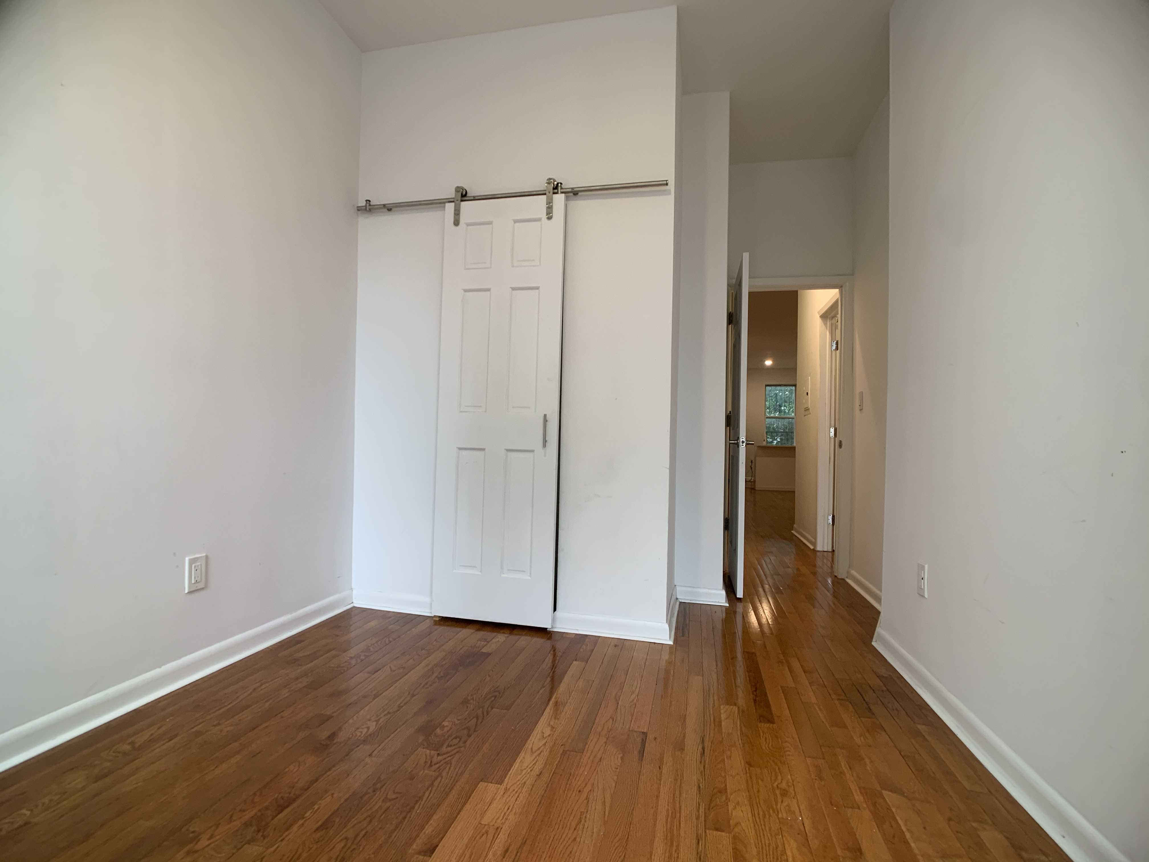 293 Tompkins Avenue Brooklyn, NY 11221 - Photo 13 of 19 a view of an empty room with wooden floor