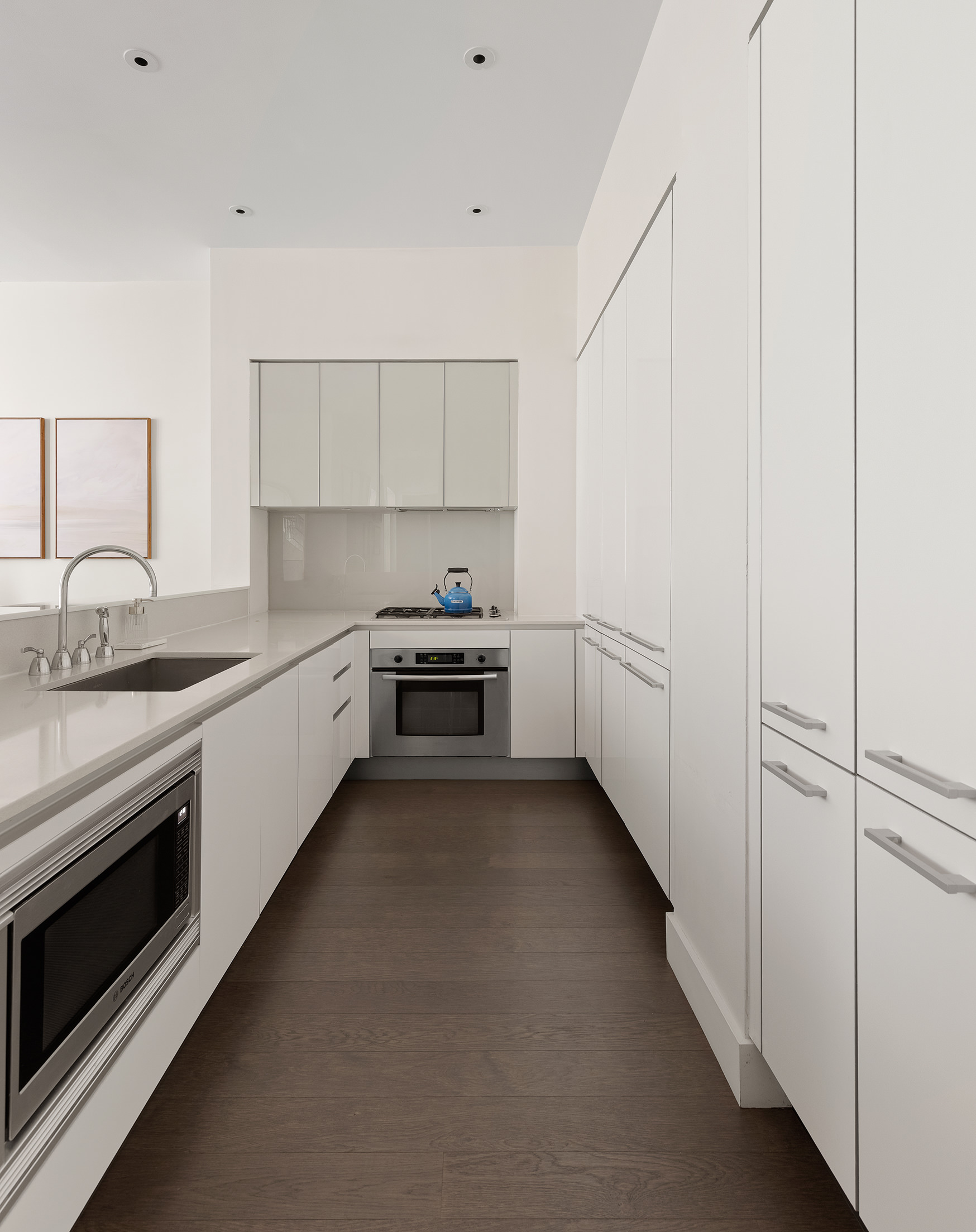 25 Broad Street, Unit 6T Manhattan, NY 10004 - Photo 4 of 13 a kitchen with white cabinets and white appliances