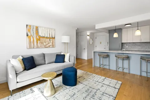 a living room with furniture and a kitchen view
