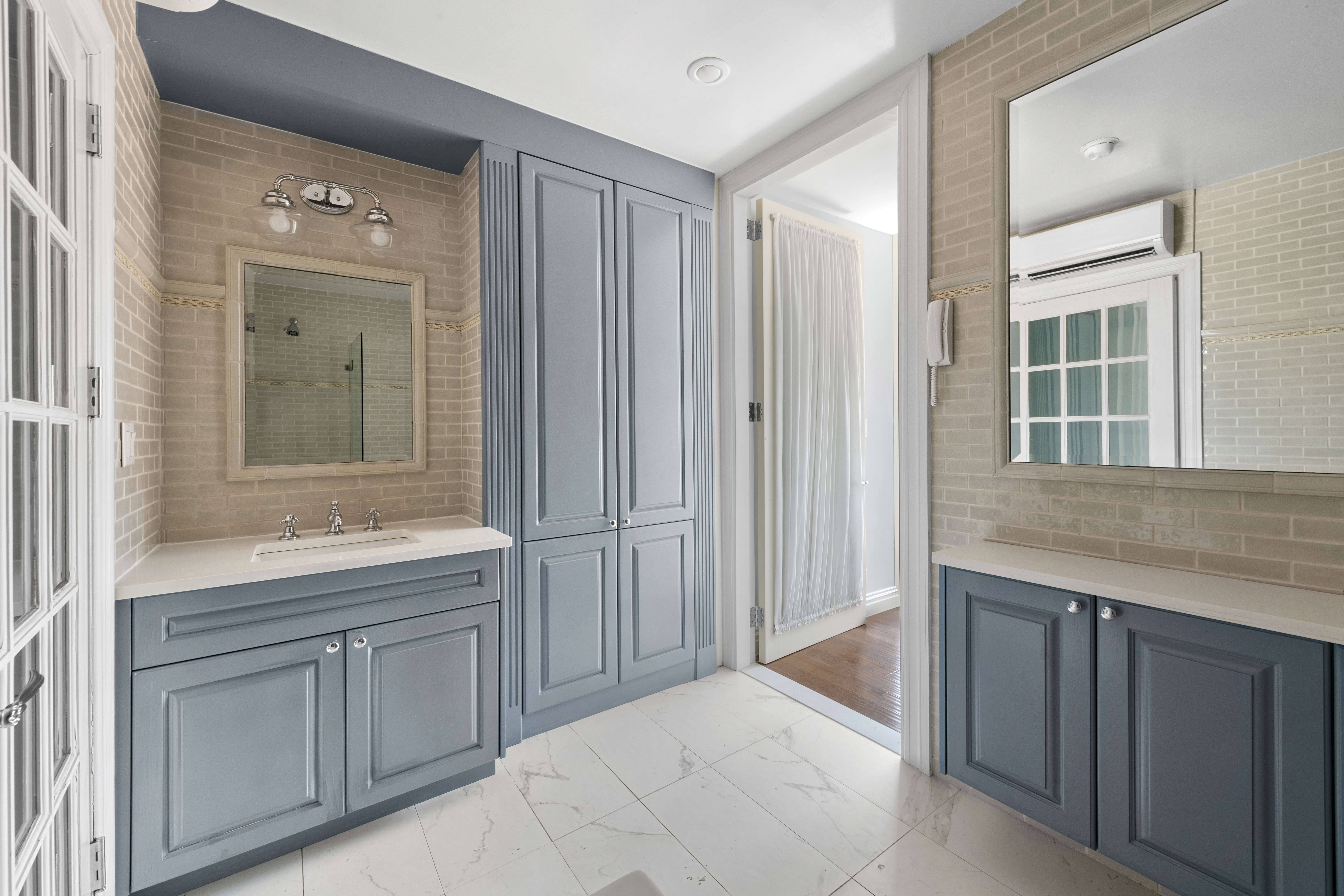 393 West 49th Street, Unit 5NN Manhattan, NY 10019 - Photo 9 of 13 a spacious bathroom with a granite countertop sink and mirror with bathtub