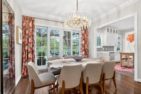 a view of a dining room with furniture a chandelier and wooden floor
