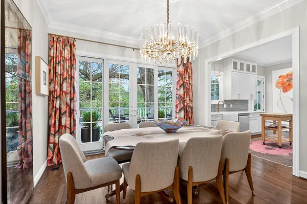 a view of a dining room with furniture a chandelier and wooden floor