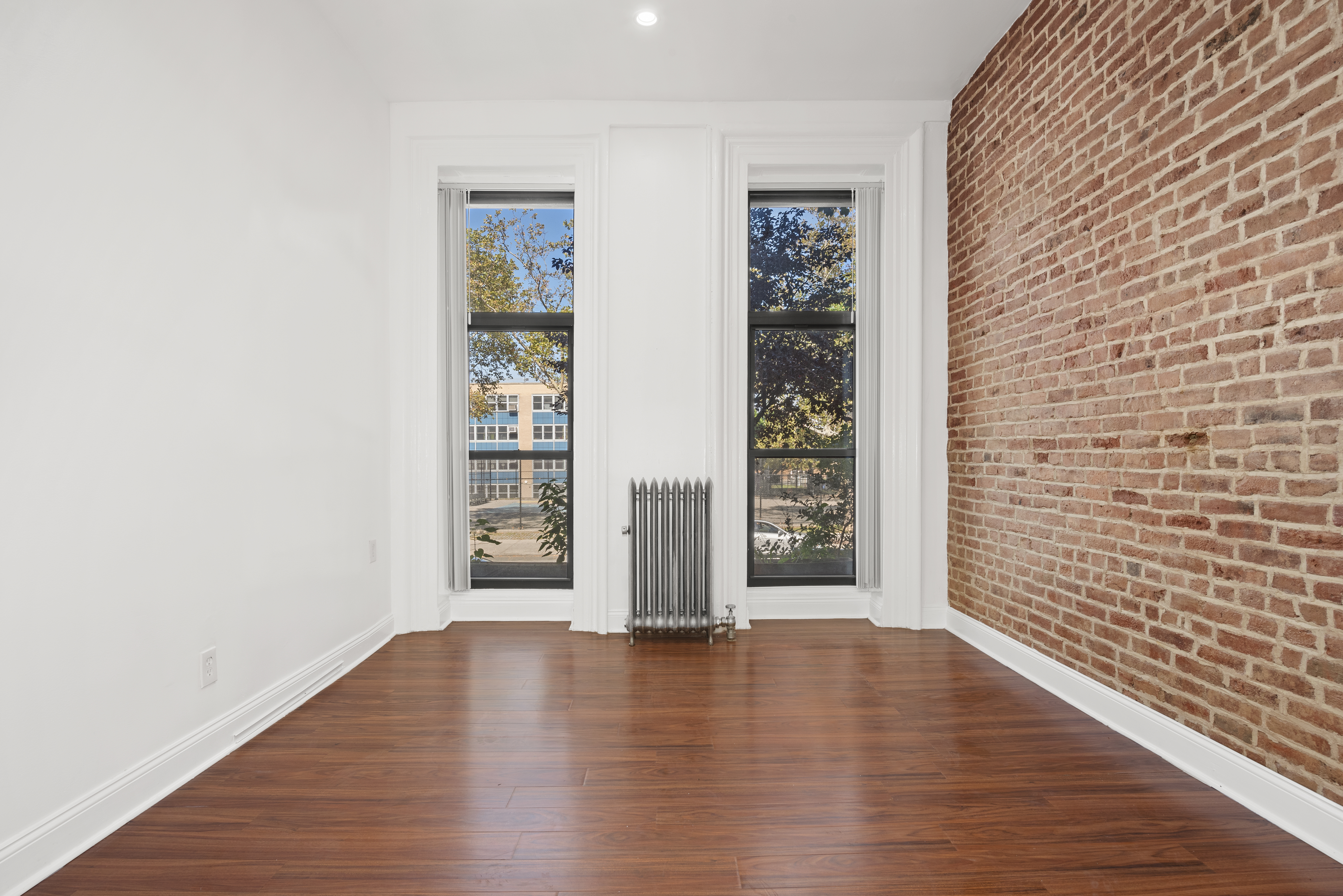 654 Lafayette Avenue, Unit GARDENA Brooklyn, NY 11216 - Photo 4 of 14 a view of an empty room with wooden floor and a window