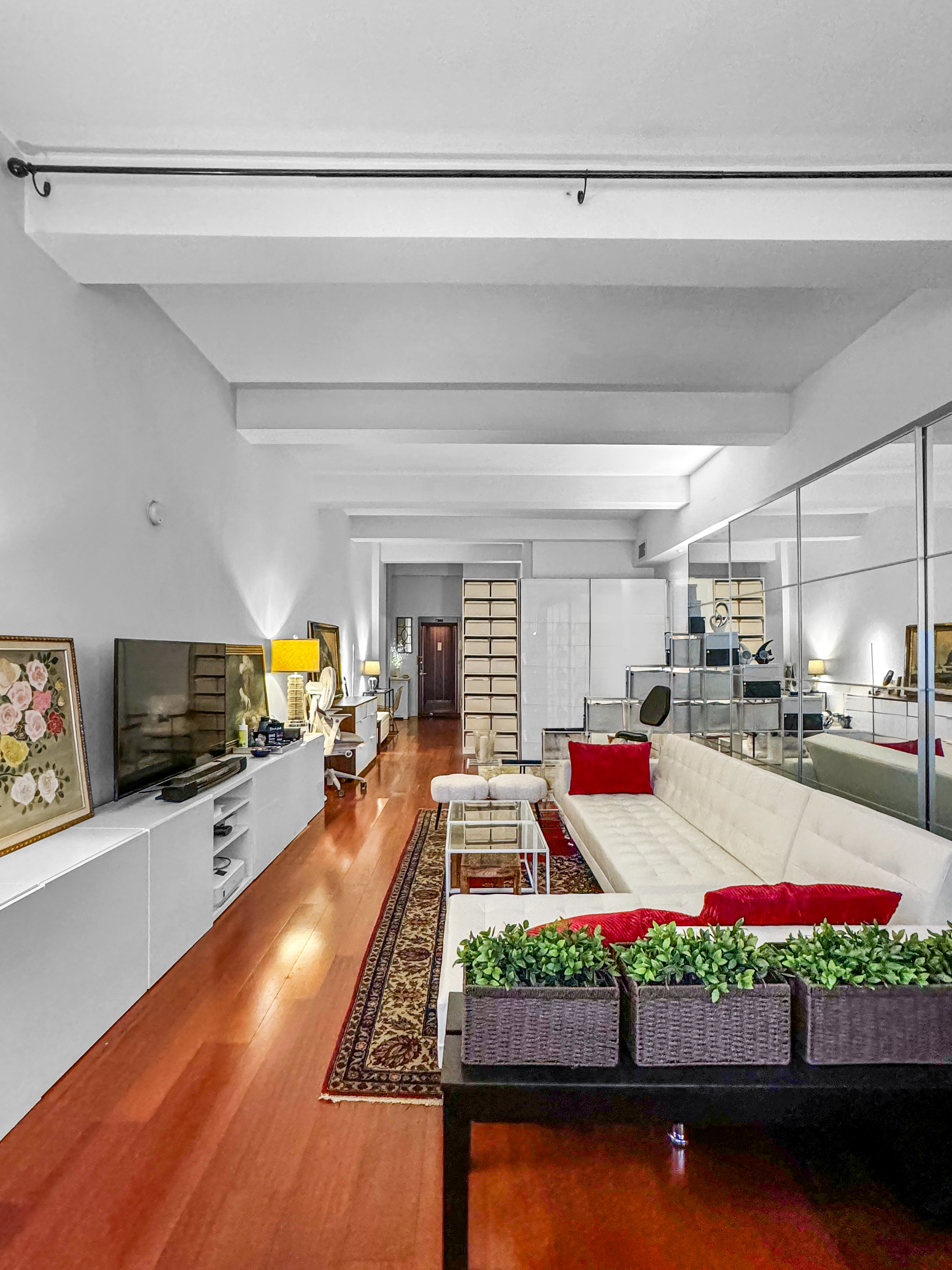 80 John Street, Unit 10D Manhattan, NY 10038 - Photo 2 of 6 a living room filled with furniture and a flat screen tv