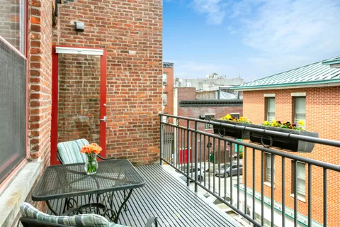 a view of a balcony with two chairs and a table with wooden floor