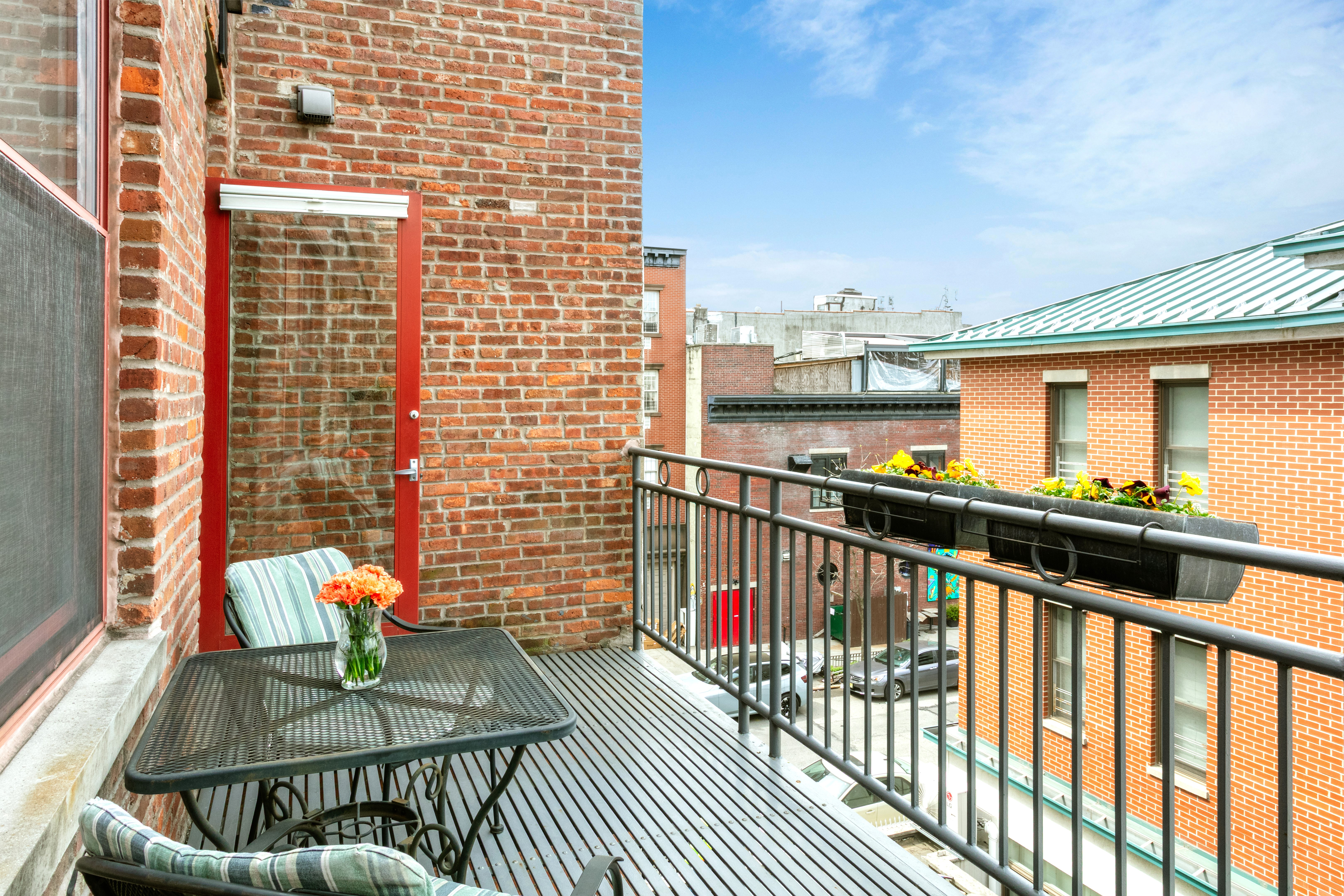 60 Tiffany Place, Unit 3C Brooklyn, NY 11231 - Photo 3 of 10 a view of a balcony with two chairs and a table with wooden floor
