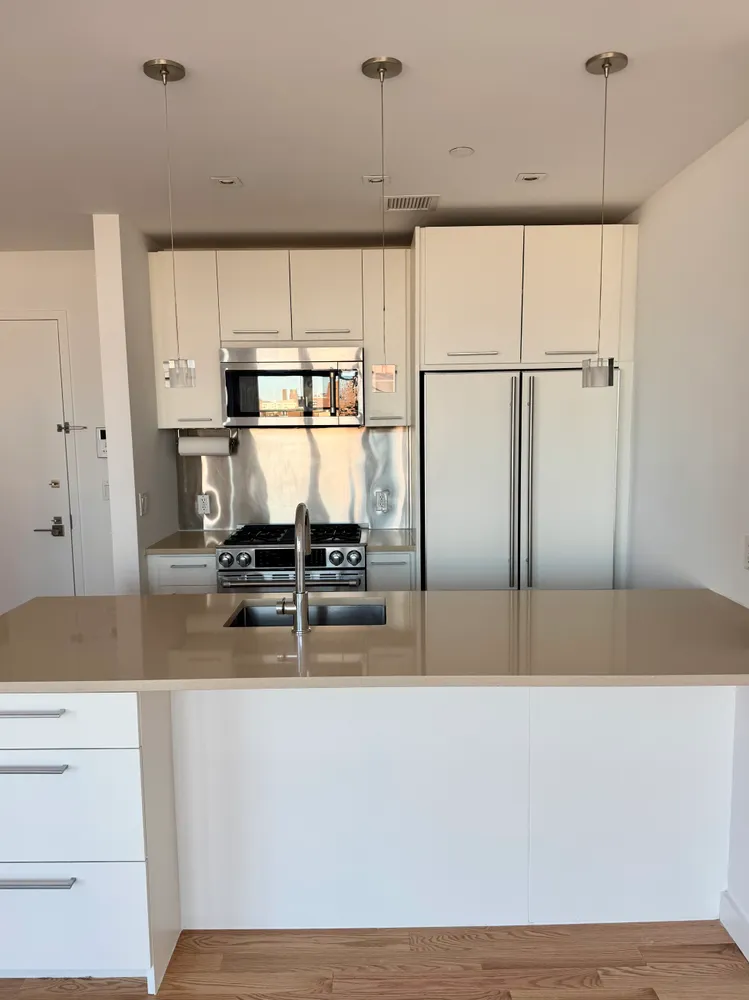 a kitchen with kitchen island a stove a refrigerator and a counter space
