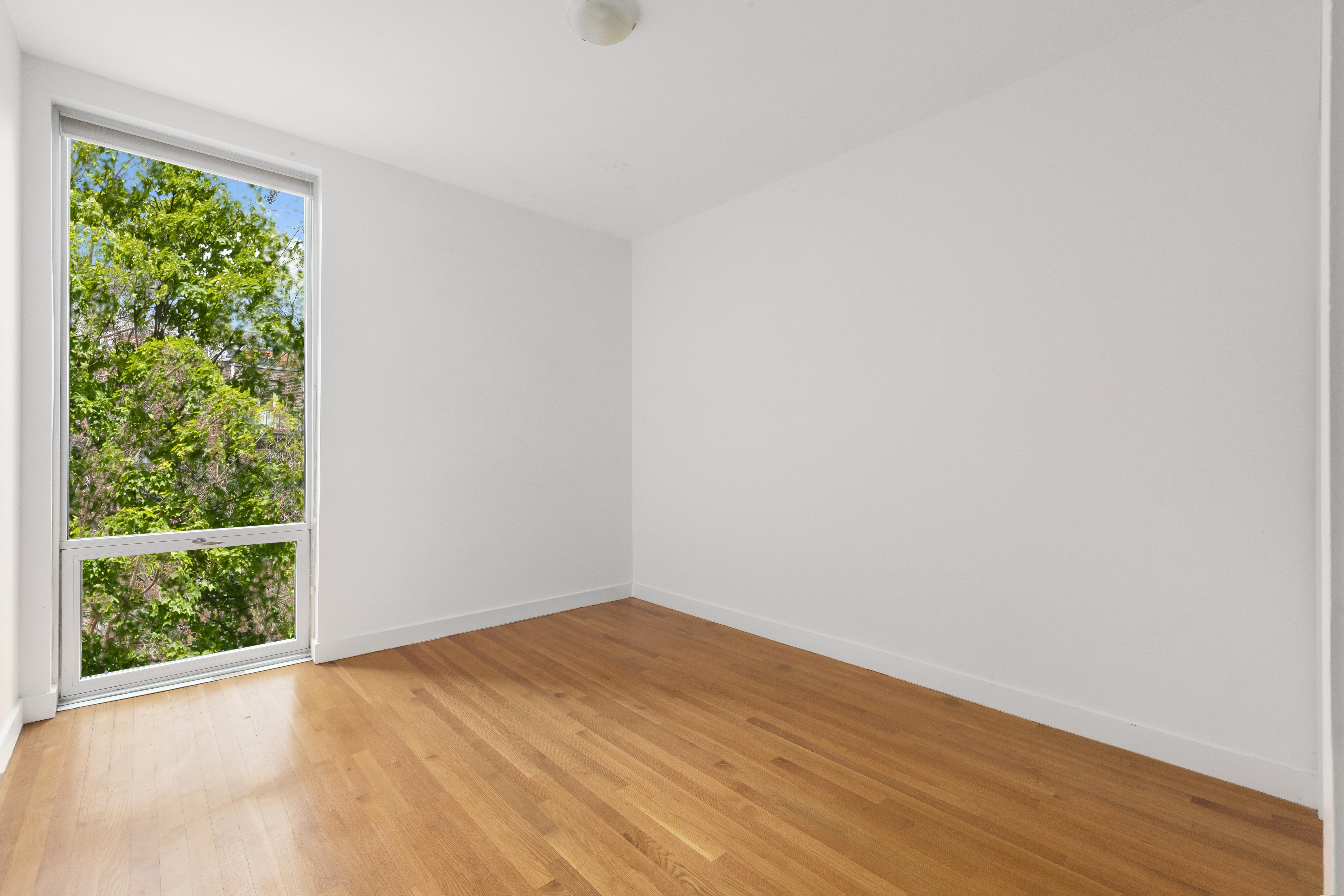 232 7th Street, Unit 3B Brooklyn, NY 11215 - Photo 7 of 7 an empty room with wooden floor and windows