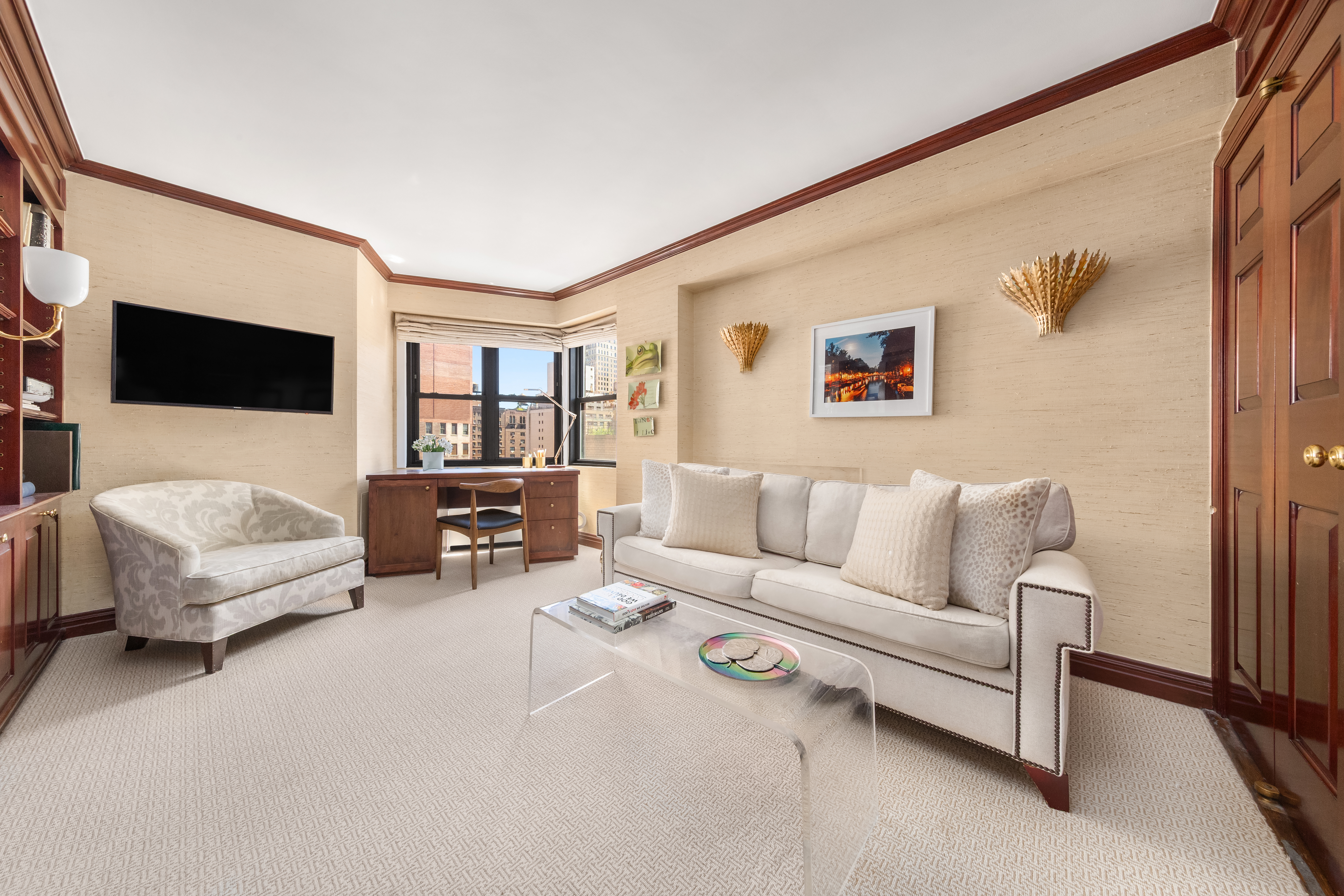 201 East 77th Street, Unit 14AF Manhattan, NY 10075 - Photo 8 of 13 a living room with furniture and a flat screen tv