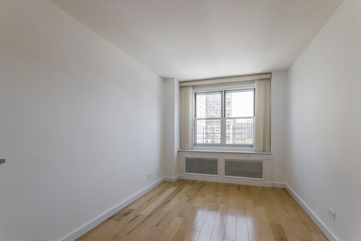 1270 5th Avenue, Unit 12C Manhattan, NY 10029 - Photo 10 of 18 an empty room with wooden floor and windows