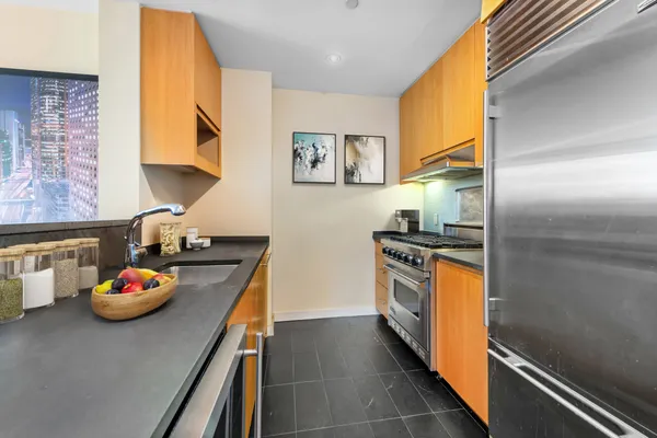 a kitchen with stainless steel appliances granite countertop a sink stove and refrigerator