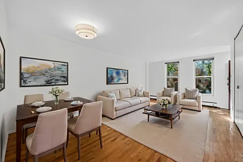 a living room with couches a coffee table and next to a window