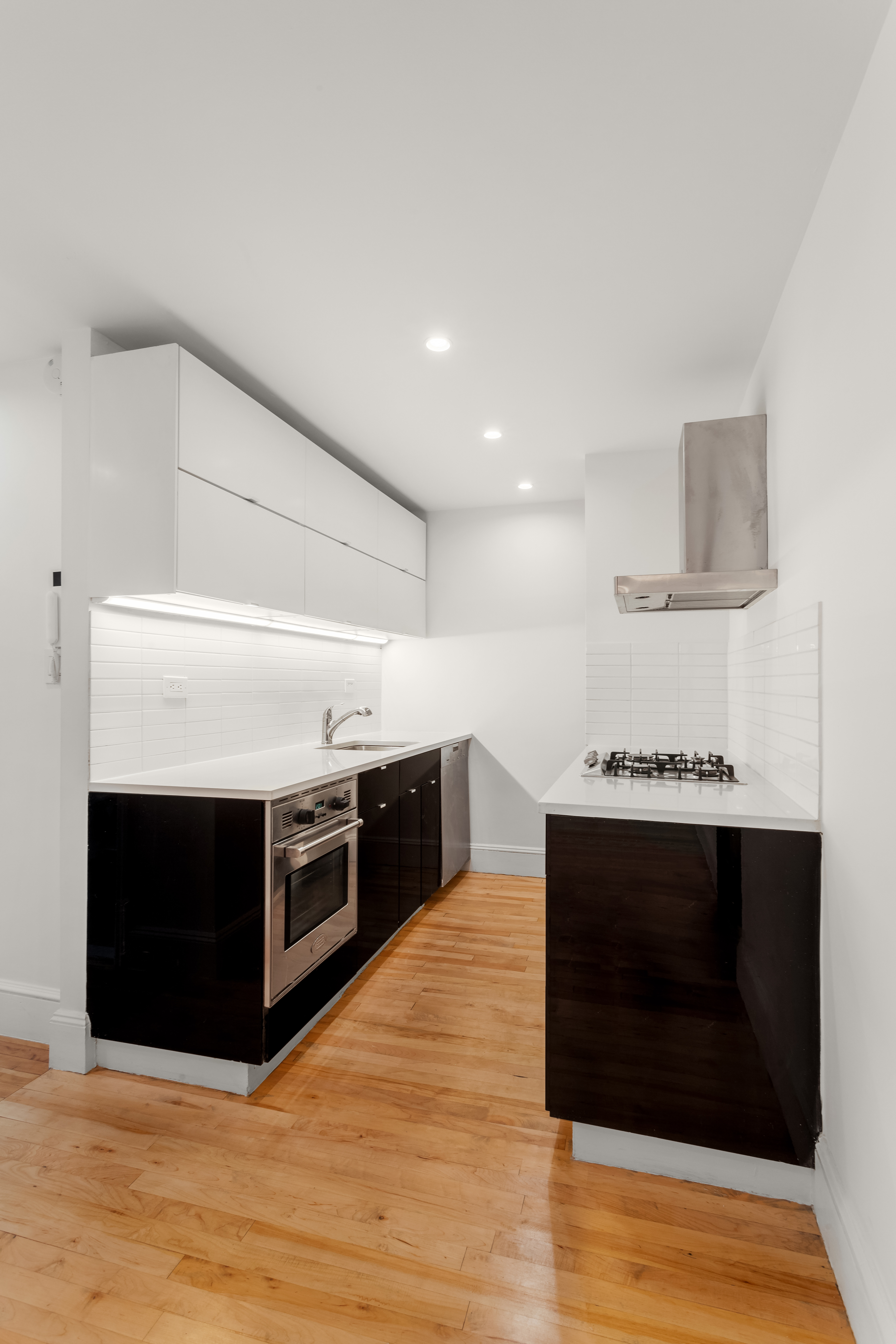 305 West 18th Street, Unit 4C Manhattan, NY 10011 - Photo 3 of 7 a kitchen with stainless steel appliances a stove and a wooden floor