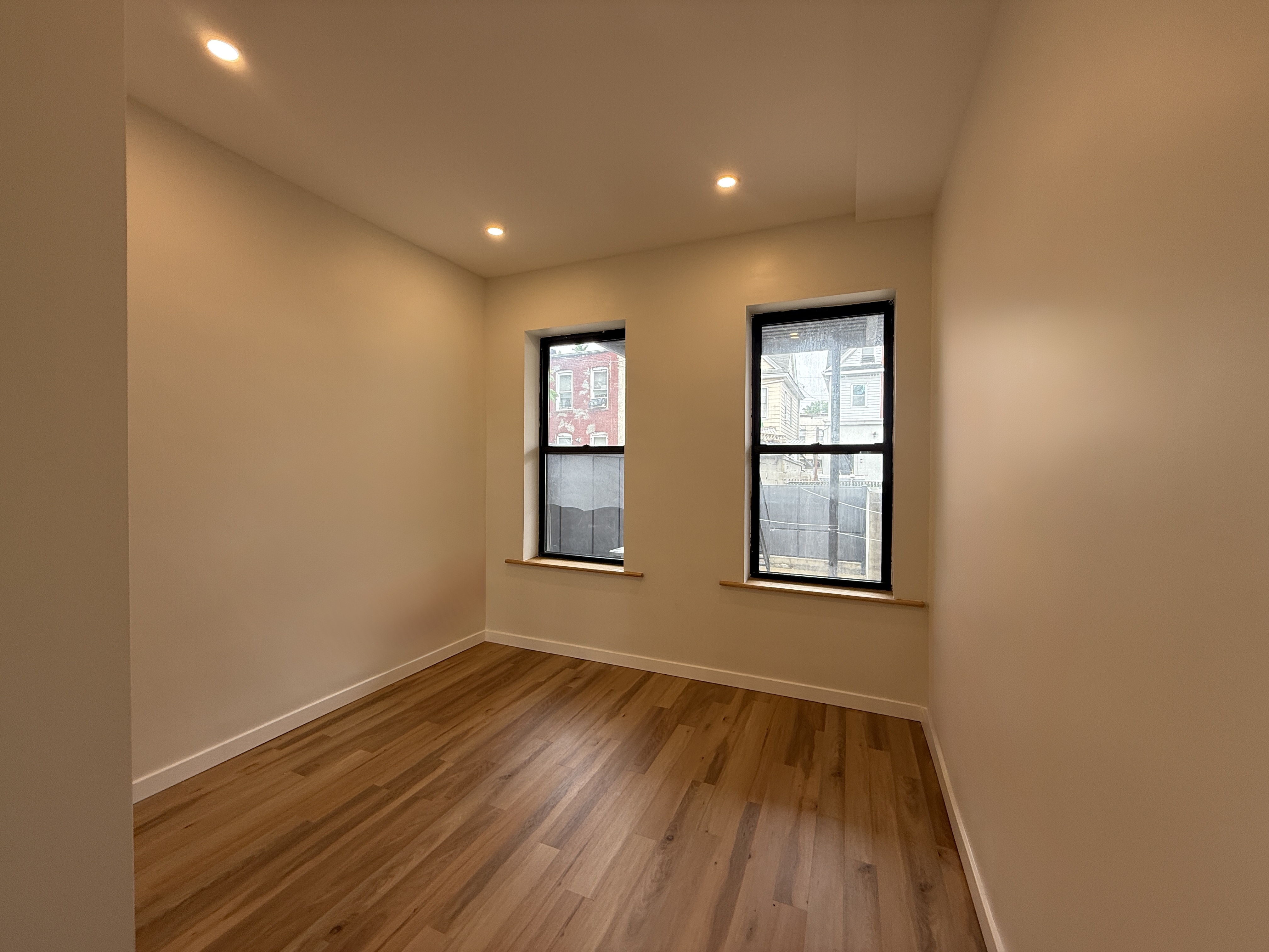 139 Autumn Avenue, Unit 1 Brooklyn, NY 11208 - Photo 9 of 14 a view of an empty room with wooden floor and a window