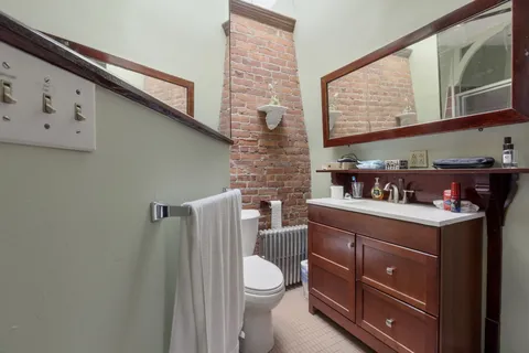 a bathroom with a toilet a sink and mirror