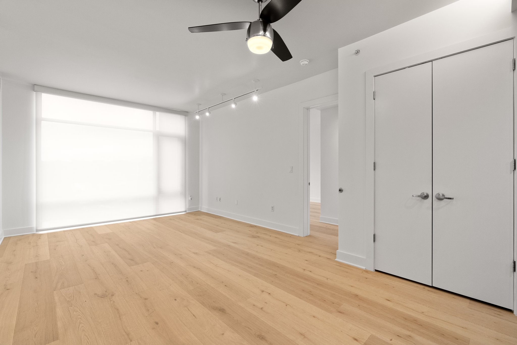 210 Lee Barton Drive, Unit 517 Austin, TX 78704 - Photo 8 of 32 a view of an empty room with wooden floor and fan