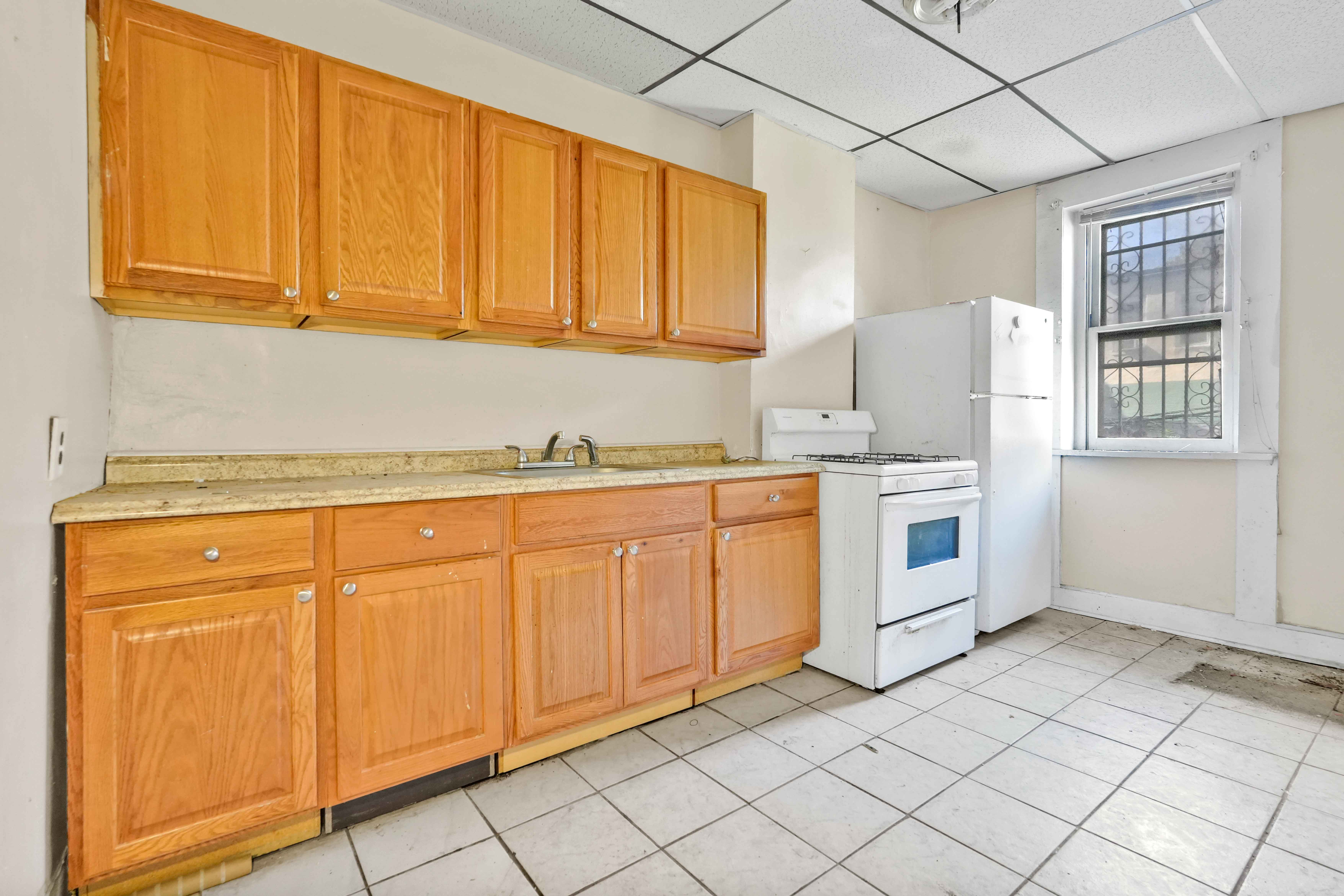 610 Ashford Street Brooklyn, NY 11207 - Photo 18 of 28 a kitchen with granite countertop cabinets and white appliances