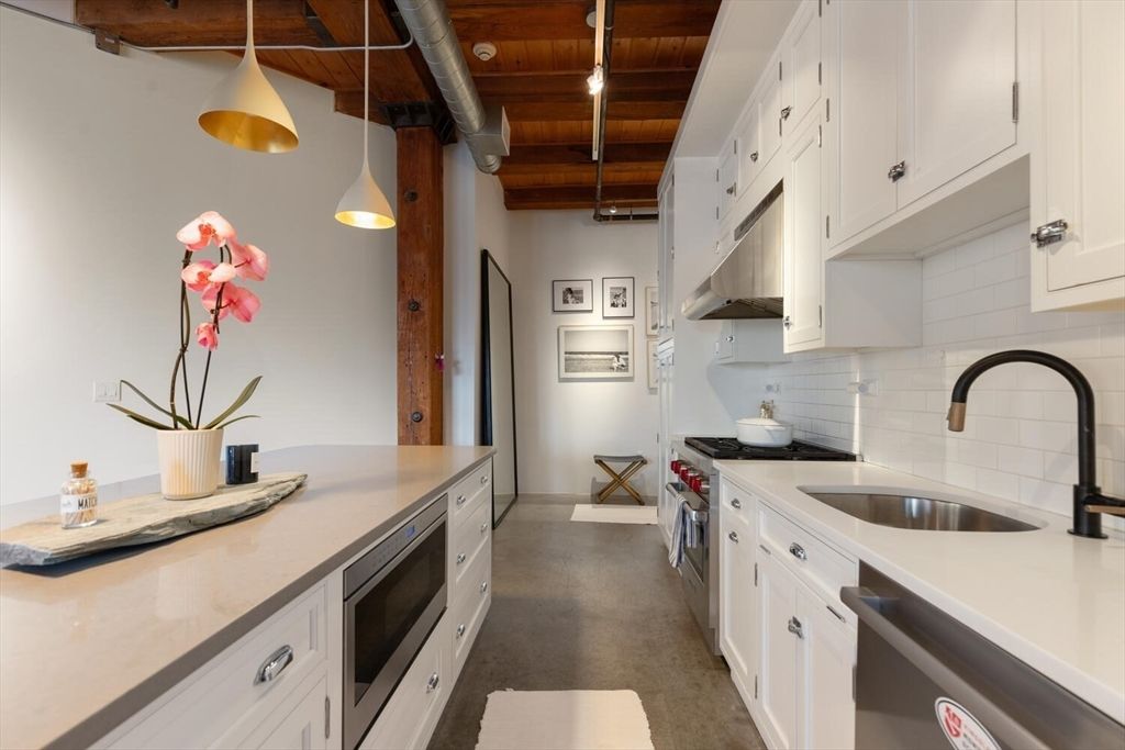a kitchen with kitchen island a sink appliances cabinets and a counter top space