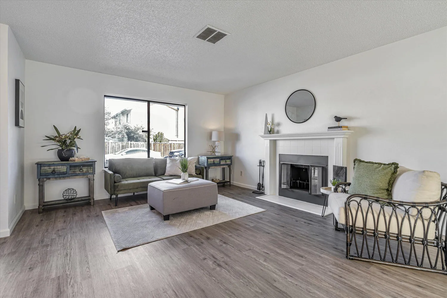 a living room with furniture a large window and wooden floor