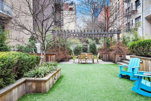 a view of a chair and table in the back yard of the house