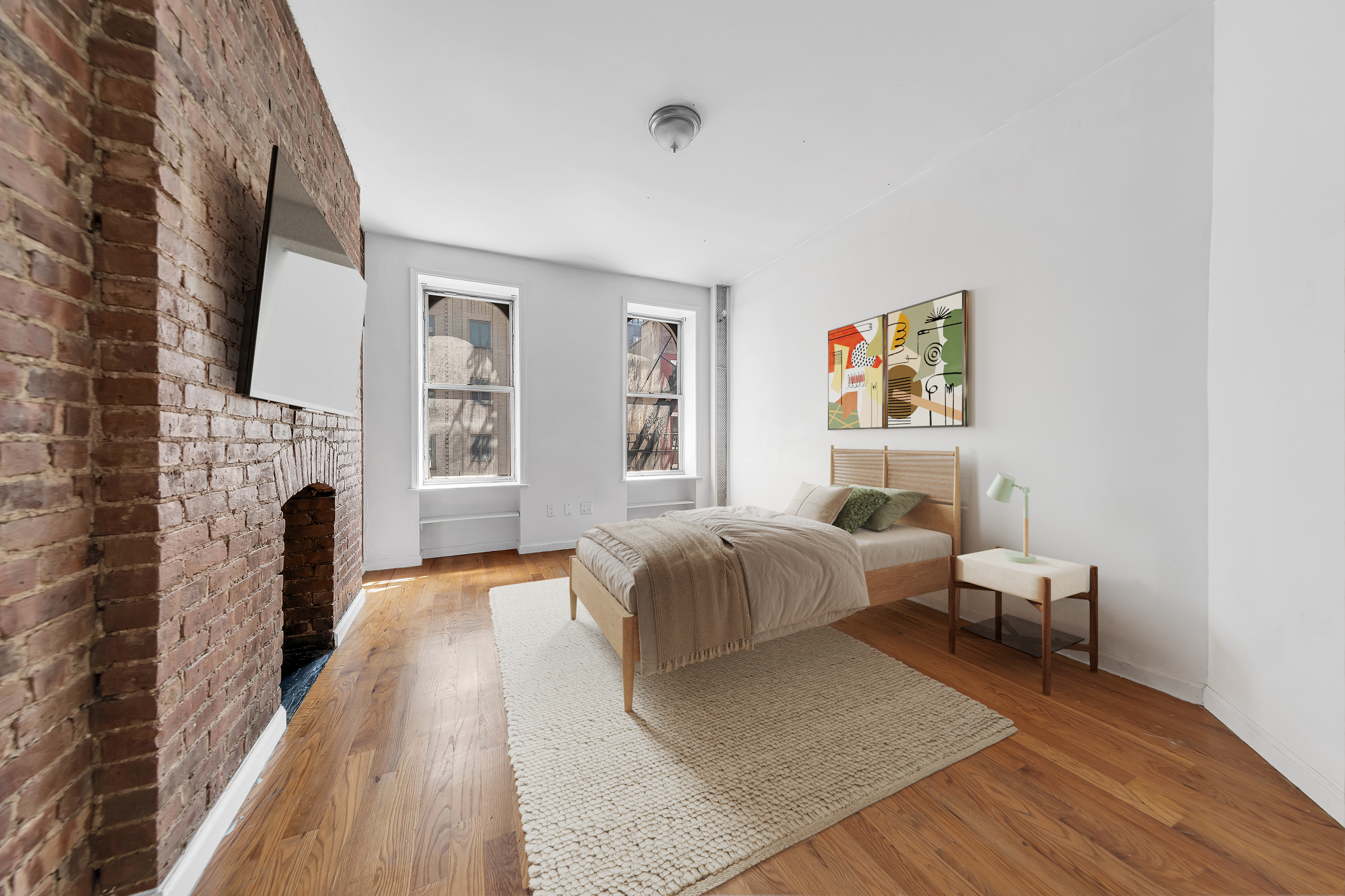 205 West 20th Street, Unit 2W Manhattan, NY 10011 - Photo 2 of 5 a spacious bedroom with a bed and a fireplace
