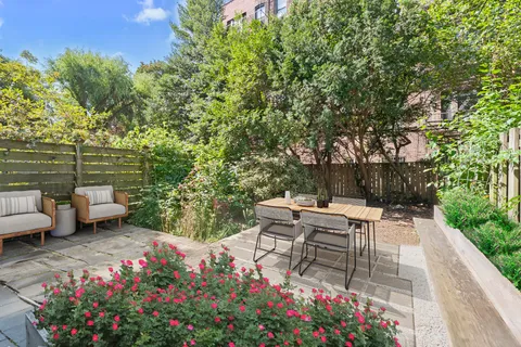 a view of a patio with couches table and chairs potted plants and large tree
