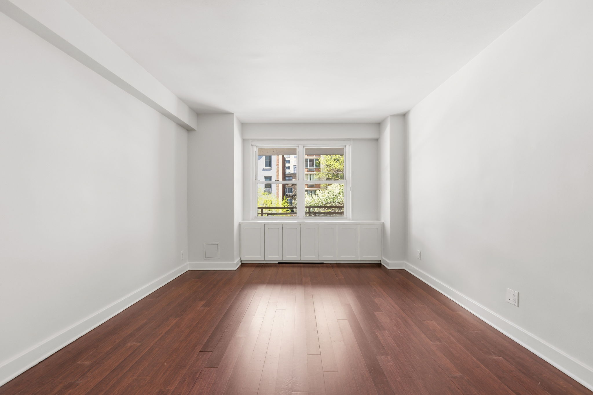 360 East 72nd Street, Unit A306 Manhattan, NY 10021 - Photo 10 of 17 an empty room with wooden floor and windows