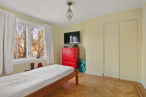 a bedroom with a bed dresser and a window