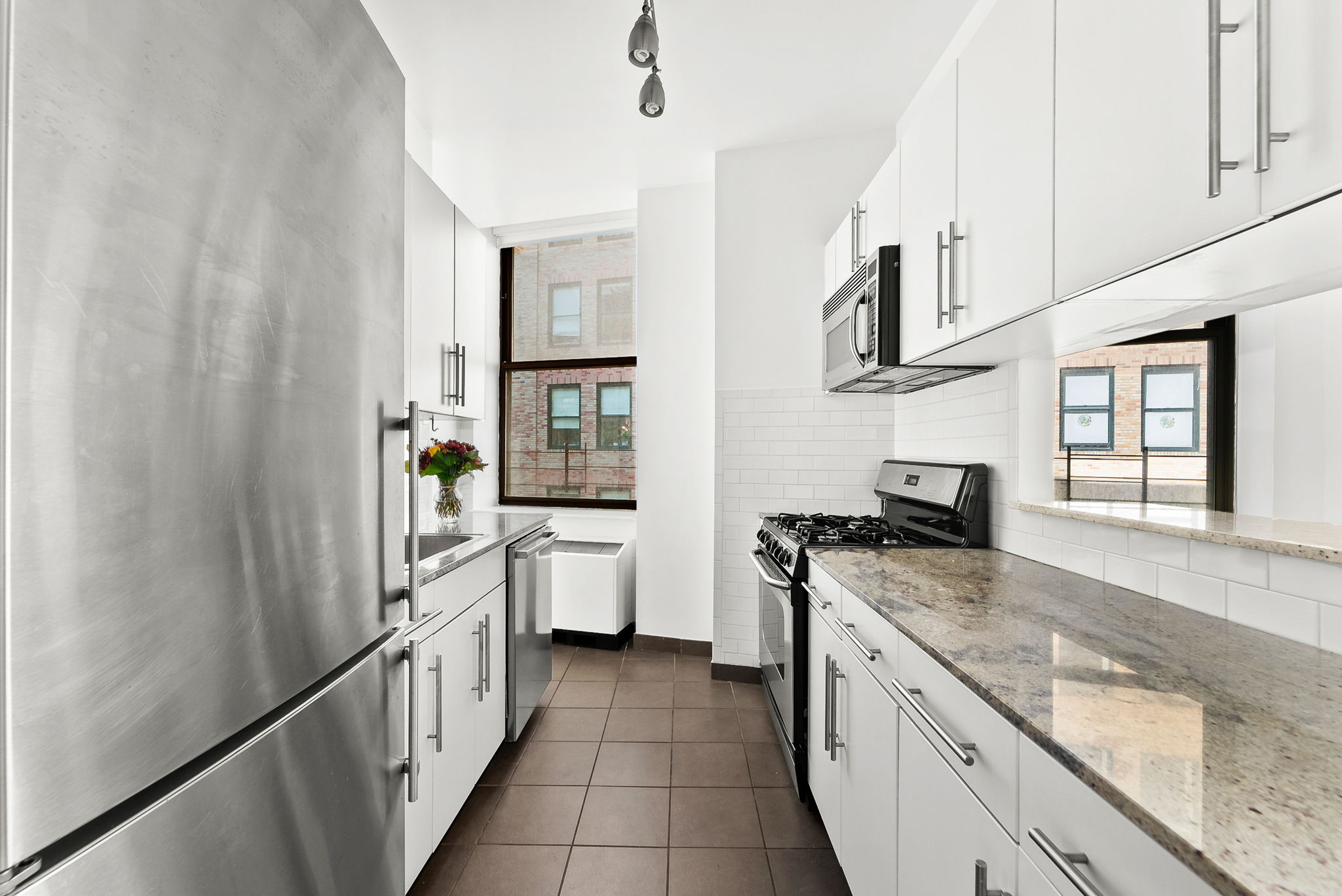 1 Wall Street Court, Unit 1405 Manhattan, NY 10005 - Photo 8 of 19 a kitchen with stainless steel appliances granite countertop a sink and a stove top oven