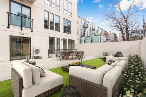 a view of a patio with couches table and chairs and potted plants
